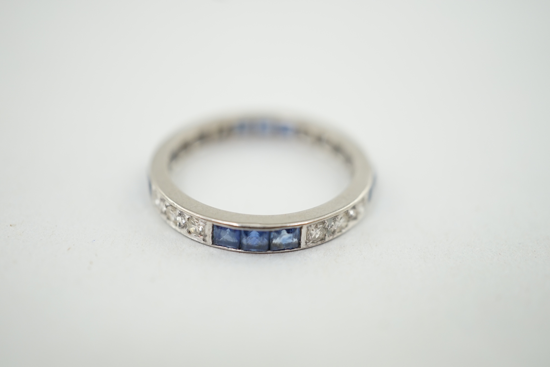 A white gold, twelve stone sapphire and twelve stone diamond set full eternity ring